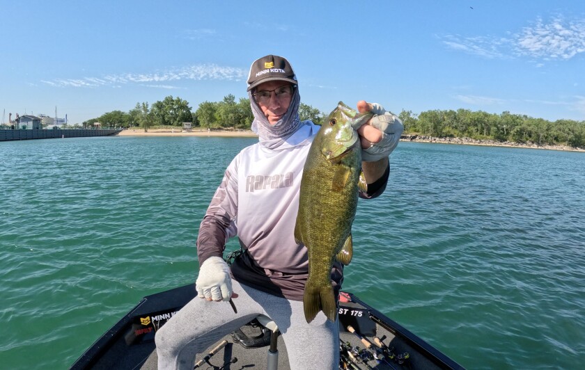 Bob Johnson with a smallmouth bass in Indiana waters of Lake Michigan out of East Chicago. Prvided