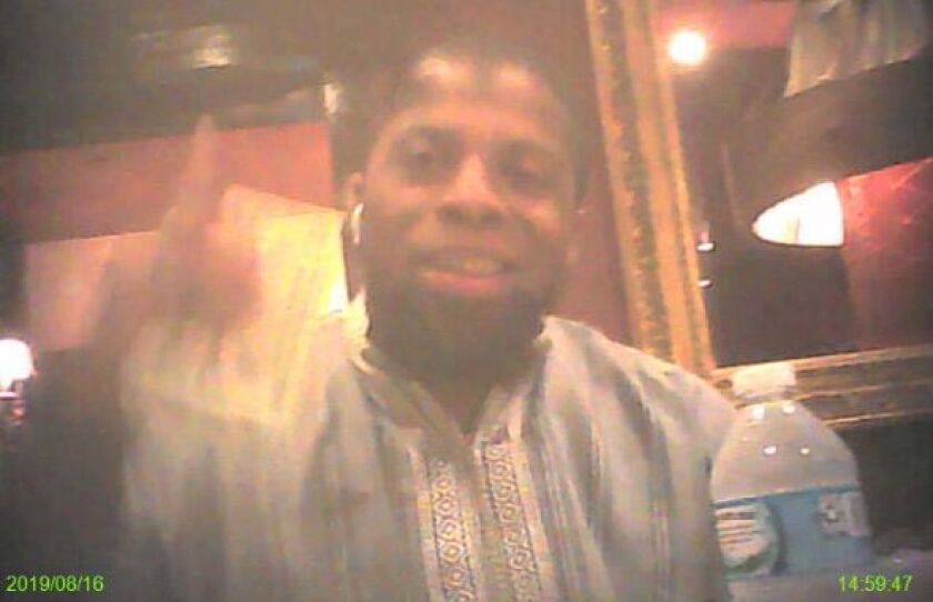 In this still image from a video-recording made by a federal informant meeting with Jason Brown in August, Brown holds $500 in cash and allegedly says, “Allah Knows.”