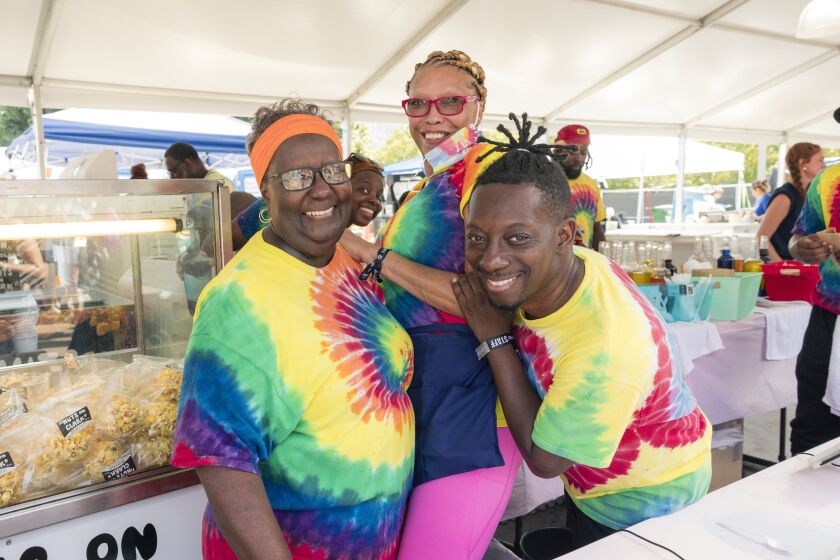 Oretha Winston (from left), Lori Hardiman, Lea Exson and Russell Winston pose for a photo at their booth, Harris Snow Cones, during day one of Lollapalooza.