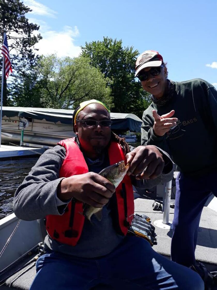 DJ Fyre unhooks a fish on the Wisconsin River with Rob Abouchar in the background. Provided photo