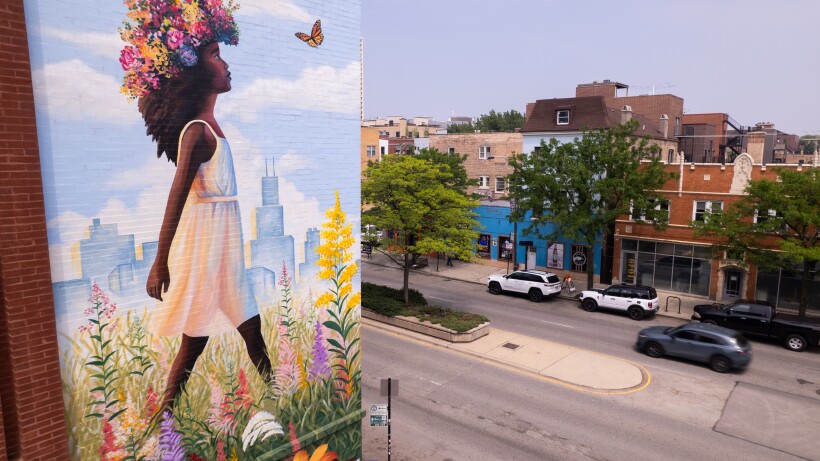 A West Town mural shows a girl with a flower crown walking through a field with the Chicago skyline depicted in the background.