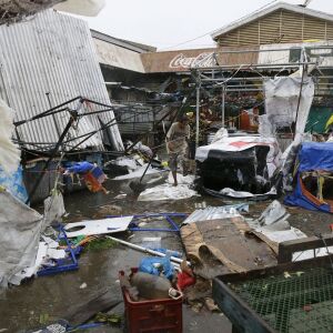 Residents walk along destroyed stalls at a public market due to strong winds as Typhoon Mangkhut barreled across Tuguegrao city in Cagayan province, northeastern Philippines on Saturday, Sept. 15, 2018. The typhoon slammed into the Philippines northeaster