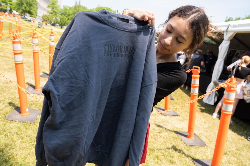 Catalina Dominguez, 17, from Chicago, shows off a blue Taylor Swift crewneck sweatshirt that she bought outside Soldier Field.