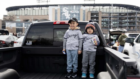 Brothers Jacob (right), 4, and Camryn, 6, stand on their dad’s truck on Opening Day outside Rate Field in Bridgeport