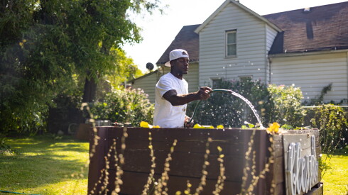 Nakia Smith waters recently planted collard greens Monday in his community garden in Roseland on the Far South Side.