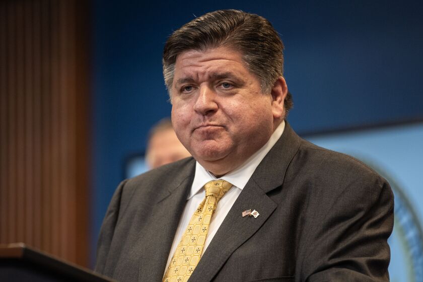 Gov. J.B. Pritzker listens during a news conference in the Greektown neighborhood earlier this month.