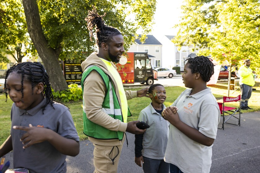 Rayqwan Alexander, de 32 años de edad y trabajador de alcance del Instituto para la No Violencia de Chicago, conversa con niños que piden pintarse la cara durante un evento de alcance en West Garfield Park en septiembre de 2025.