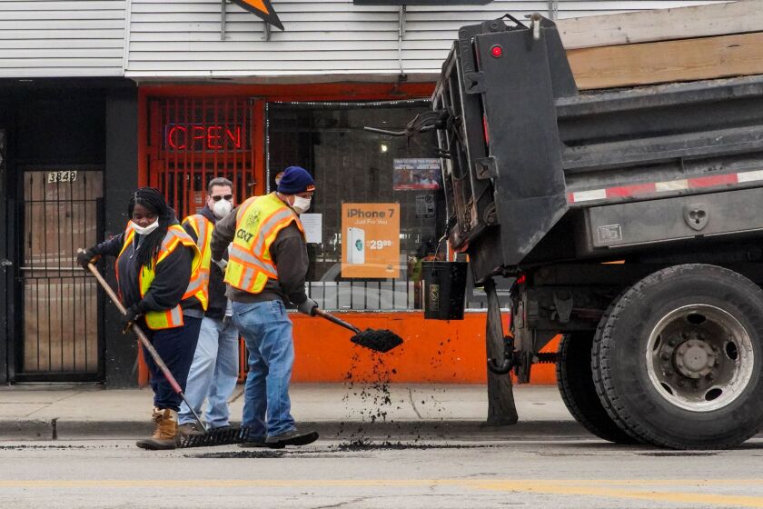 Chicago Department of Transportation workers fill potholes Friday near Madison Street and Springfield Avenue as the Chicago Police Department’s 11th District CAPS Office hosts Operation Clean.
