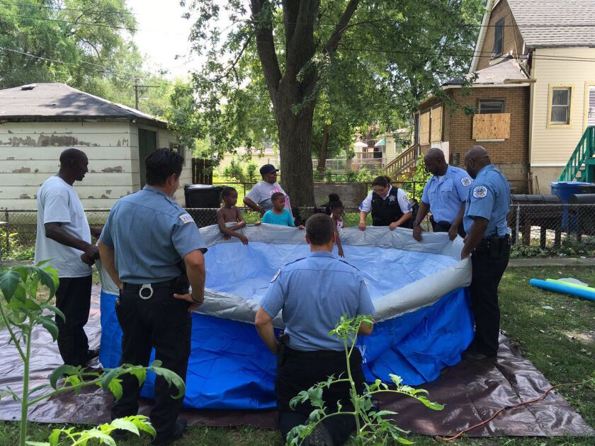 Chicago Police officers hold up the sides of the new pool in Tacarra Morgan’s backyard. | Maudlyne Ihejirika/Sun-Times