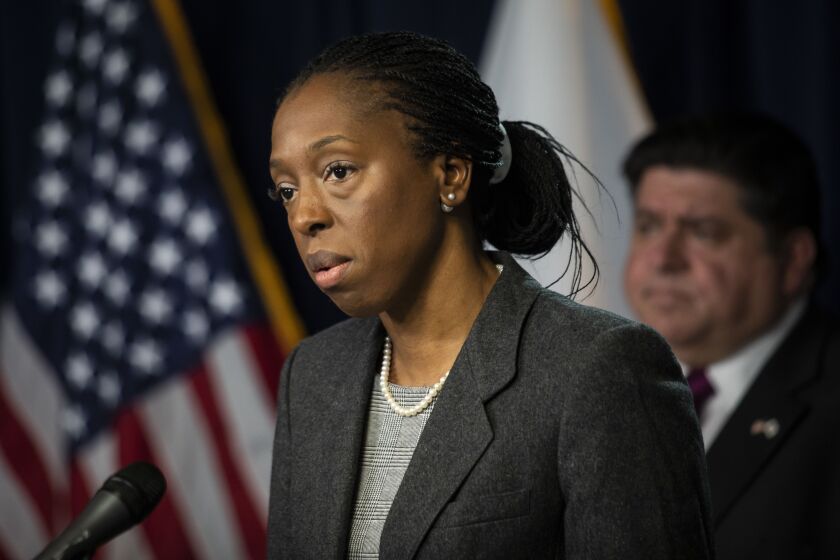 Illinois Public Health Director Dr. Ngozi Ezike speaks at the Thompson Center during a March 30 news briefing as Gov. J.B. Pritzker looks on.