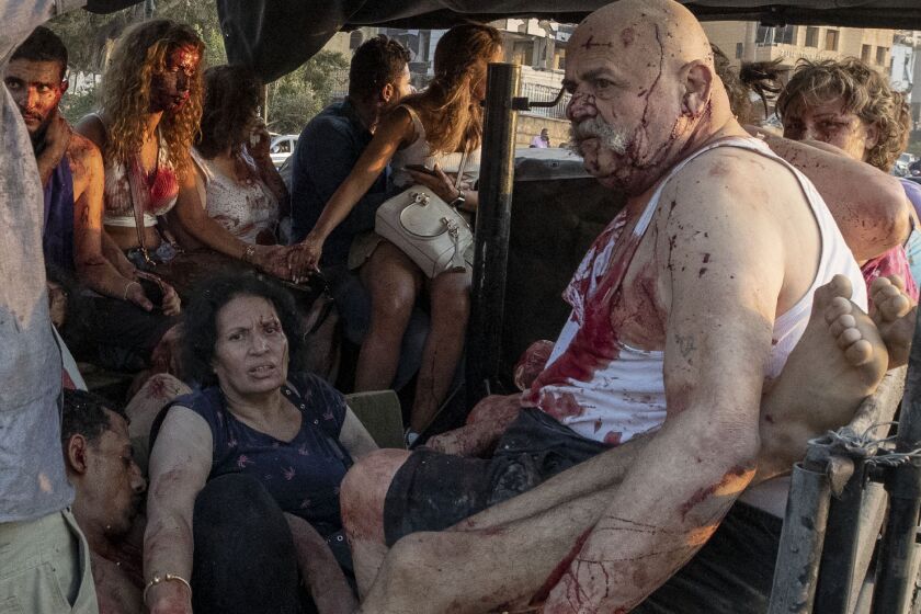 Injured people are evacuated Aug. 4, 2020, by a military truck after a massive explosion at Beirut’s port tore through the city. destroying neighborhoods and killing scores of people, including several at St. George Hospital.