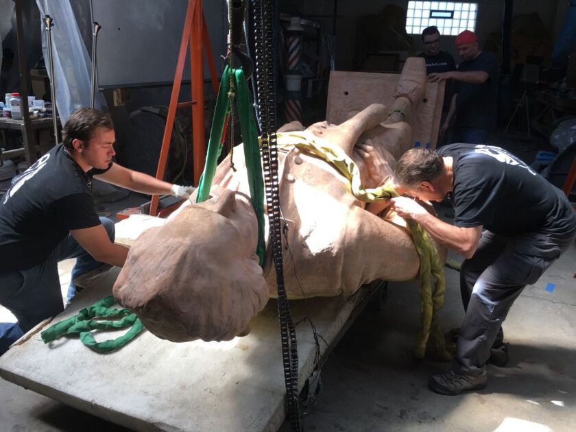 Johnathan Murach, Christopher Ciaston, Robert Zarycki (red hat), Dr. Andrzej Dajnowski (front right adjusting a strap). The conservation team is carefully straps the sculpture to rotate it during treatment. | Bartosz Dajnowski photo