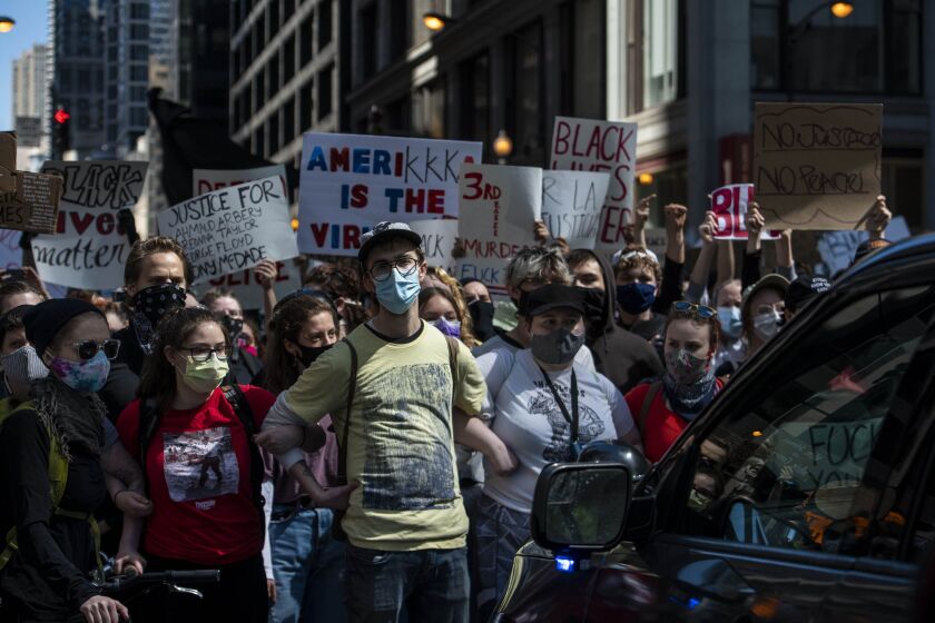 A group of protesters block police vehicles from moving forward on Dearborn, Saturday, May 30, 2020.