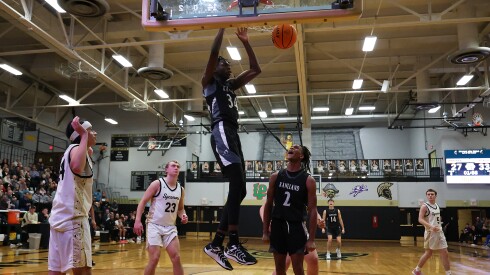 Kaneland's Jeffrey Hassan (34) dunks as his teammate Isaiah Gipson (2) yells his approval as the Knights defeat Sycamore.