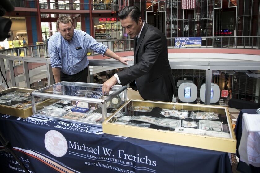 Neal Hovasse, vault manager for the Illinois state treasurer’s office, displays some of the state’s unclaimed valuables that will be auctioned off during the Illinois State Fair. | Ashlee Rezin/Sun-Times