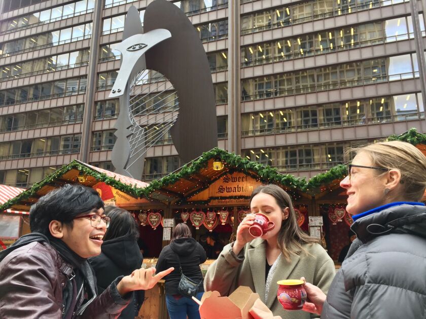 Kevin Gomez of suburban Bolingbrook, Allison Paul of Logan Square and Jen Stiemke of Irving Park share drinks and laughs during the first day of Christkindlmarket last year in Daley Plaza. | David Matthews/For the Sun-Times
