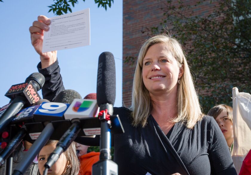Erica Hade, parent of three CPS students and member of “Parents for Teachers,” holds a protest postcard during a press conference held Monday by CPU parents on the street near Mayor Rahm Emanuel’s Ravenswood home. | Santiago Covarrubias/Sun-times