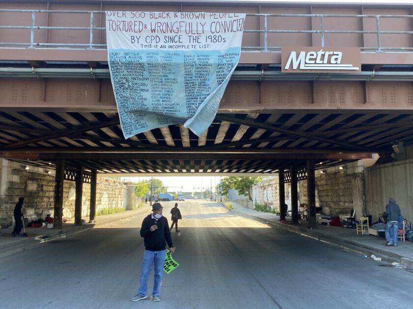 At the end of the march, protesters hung a banner from a rail viaduct; it listed hundreds of names of people organizers said had been tortured and wrongfully convicted by Chicago police.
