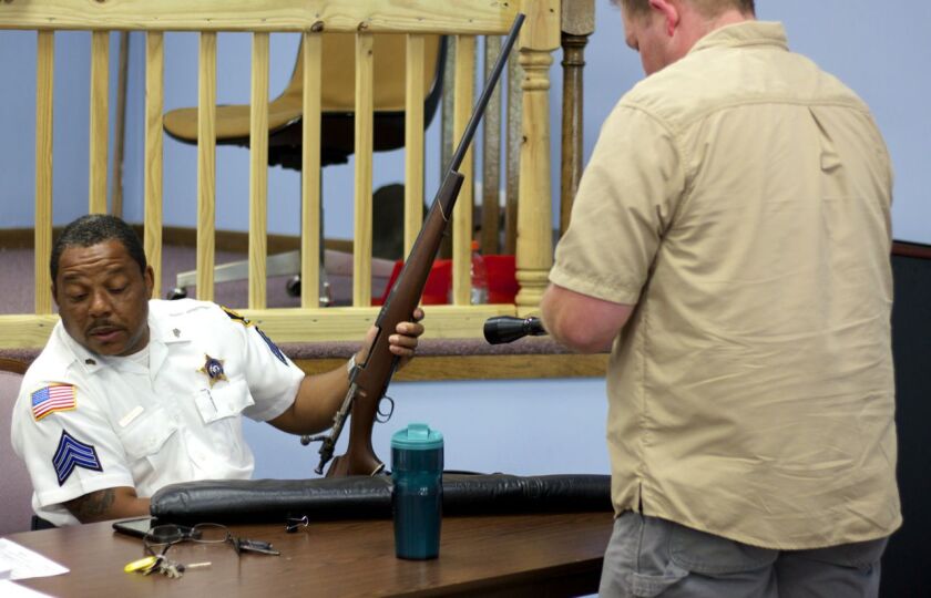 Dolton Police Sgt. Preston Allbritton takes possession of a rifle at a buy-buy on Saturday, June 3, 2017 in Dolton. | Matthew Hendrickson for the Sun-Times