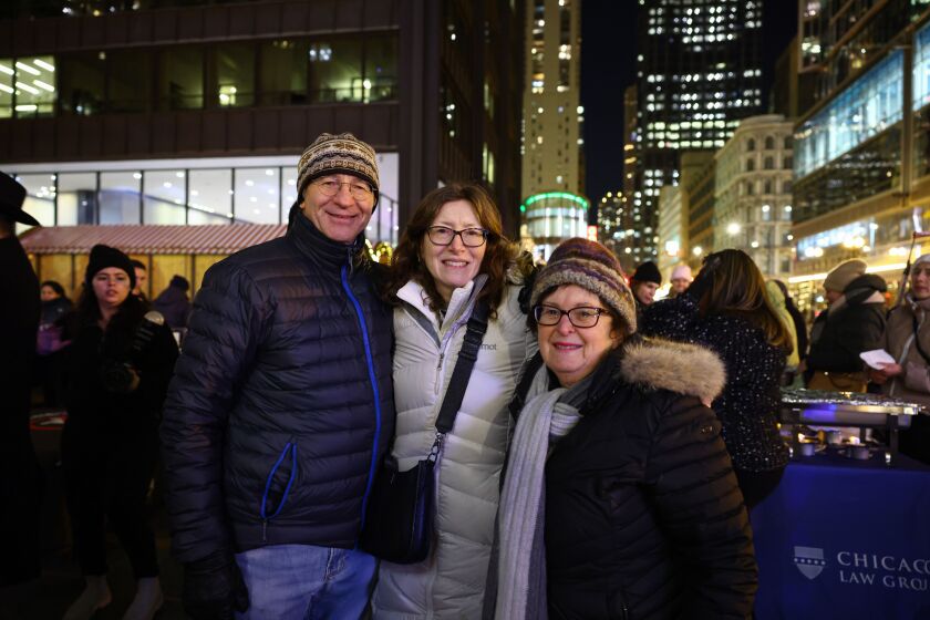 Igor Scheinman, left, Pam Scheinman and Sallie Kraus enjoyed the warmth and festive spirit of Monday’s menorah lighting in Daley Plaza. Pam Scheinman moved to Chicago from Massachusetts three years ago. Kraus, also an East Coast transplant, has attended every lighting since she arrived in town, except one at the peak of COVID-19.