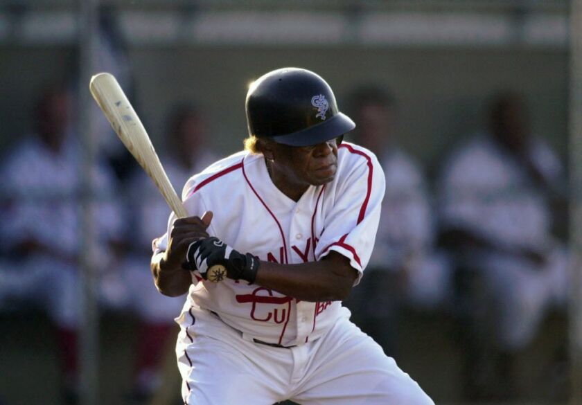 Minnie Minoso prepares to swing at a pitch, as he plays for the St. Paul Saints against Gary at Midway Stadium on Wednesday, July 16, 2003, in St. Paul, Minn. Minoso, 77, became the first player to play professional baseball in seven decades. He was in th
