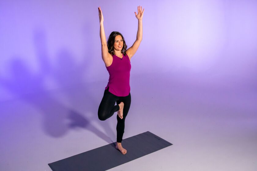Stephanie Mansour demonstrates a horse or goddess pose with an added reach, which is part of her centering yoga workout.