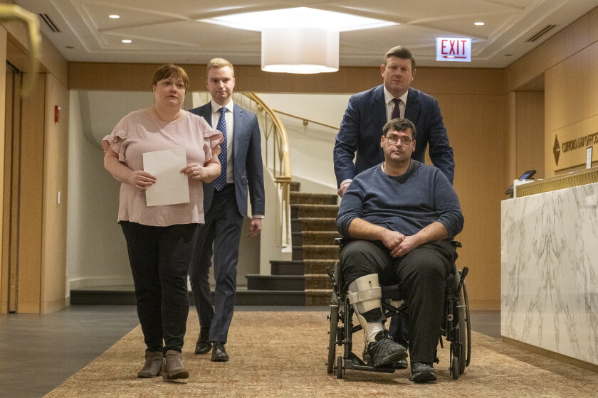 Bradley Cosgrove, a partner at Clifford Law Offices, pushes his client Antonio DeAngelo’s wheelchair into a news conference at the law firm's Loop office on Friday, March 1, 2024.