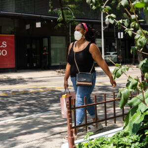 A pedestrian wearing a mask wears on North McClurg Court near East Ohio Street in Streeterville on Friday.