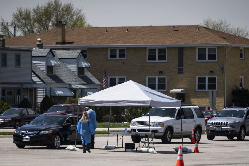 Simple Laboratories phlebotomists draw blood for coronavirus antibody testing and collect nasopharyngeal swab samples to test for COVID-19 at the lab’s drive-thru testing site in the parking lot of St. Rosalie Catholic Parish in Harwood Heights on May 1, 2020.
