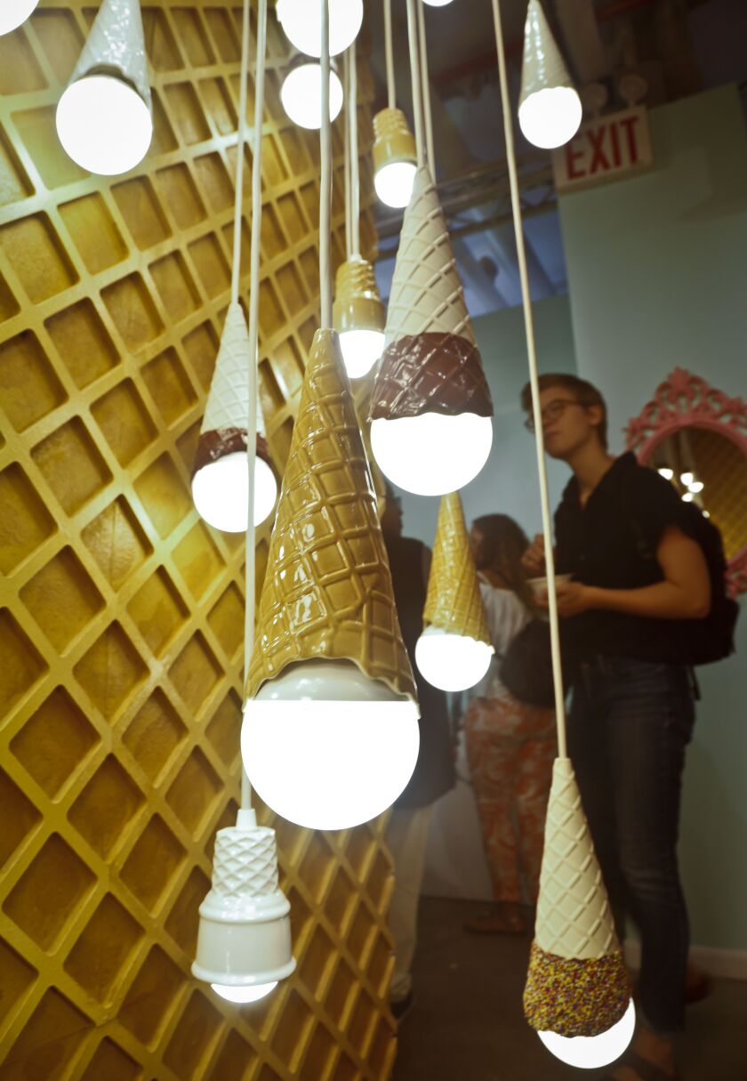A waffle light wall featuring a series of hanging ice cream cones light bulbs is among ice cream-themed works of art previewed at the Museum of Ice Cream, Thursday July 28, 2016, in New York. It opens on Friday and runs through Aug. 31. (AP Photo/Bebeto