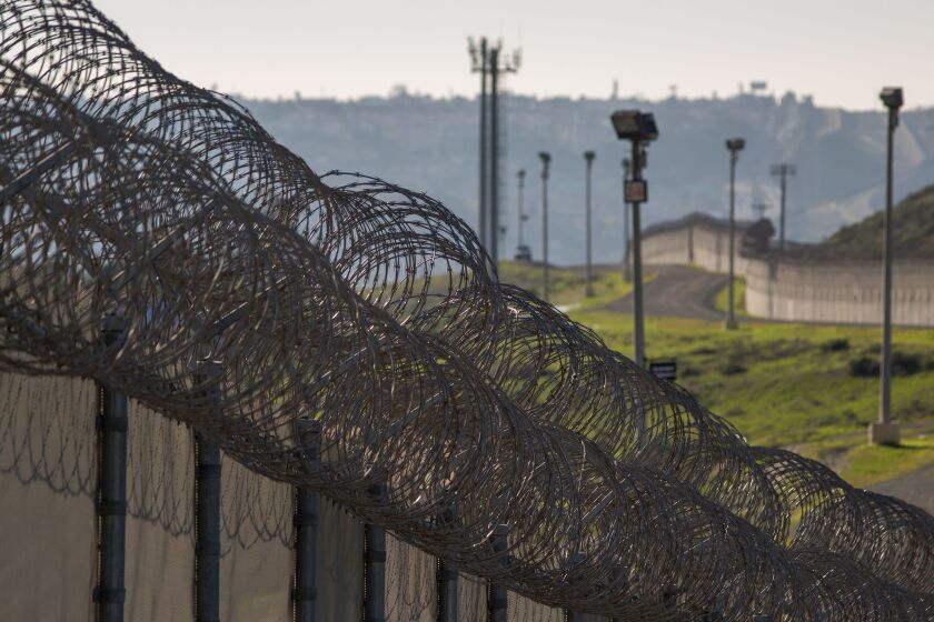Multiple layers of steel walls, fences, razor wire and other barricades are viewed from the California side of the U.S.- Mexico border.