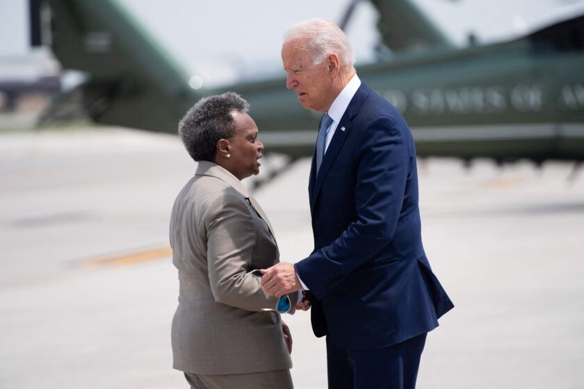 President Joe Biden greets Mayor Lori Lightfoot as he disembarks from Air Force One upon arrival at O’Hare International Airport on Wednesday.