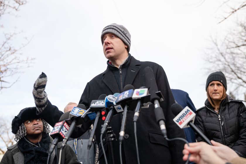 Eli Grant, a member of the Lincoln Park High School Local School Council, speaks Friday morning during a press conference outside the school.