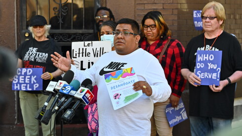 Baltazar Enriquez, executive director of the Little Village Community Council, holds a community flier while addressing media and residents during an October 8, 2026, press conference regarding an off-duty police shooting. | Victor Hilitski/For the Sun-Times