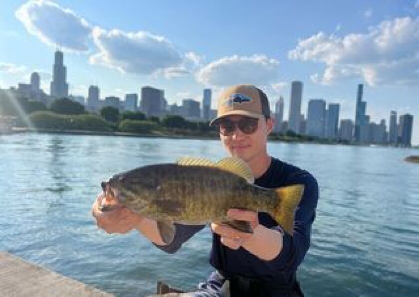 Isaiah Jeong with a smallmouth bass in a classic setting on the Chicago lakefront. Provided photo