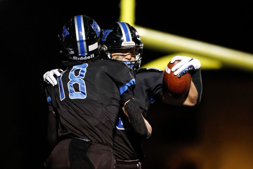 Lincoln-Way East’s Jack Tremblay (15) and Max Tomczak (18) celebrate Tremblay’s touchdown against Bollingbrook.