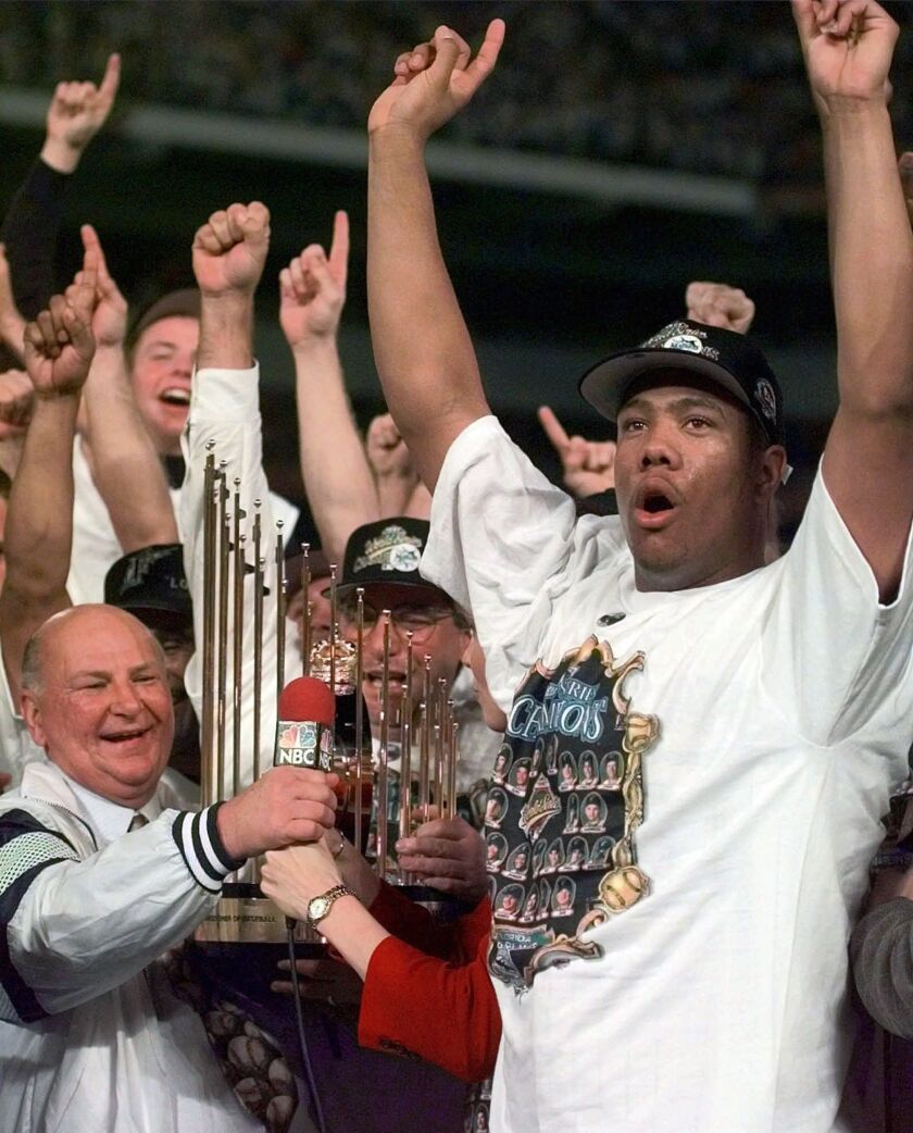 H. Wayne Huizenga, left, with Florida Marlins pitcher Livan Hernandez, holds the World Series trophy after his Florida Marlins defeated the Cleveland Indians Oct. 27, 1997, to win the World Series. | AP