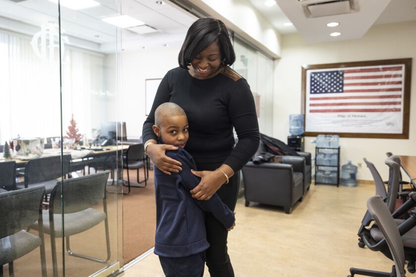 Ariana Roby, wife of fallen Chicago Fire Department firefighter Jermaine Pelt, hugs their 6-year-old son Jared, after a news conference at the Quinn Fire Academy about the EMWQ Retirees’ Widows’ and Children’s Assistance Fund, which is presenting $460,000 to 418 families of fallen CFD firefighters and EMTs, Monday, Dec. 11, 2023.
