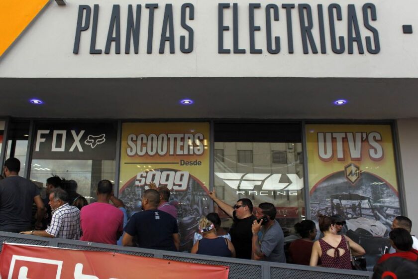 A line of customers waits for the arrival of generators at a power sports store as Hurricane Maria approaches in San Juan, Puerto Rico, on Sept. 18, 2017. | Ricardo Arduendo/AFP/Getty Images