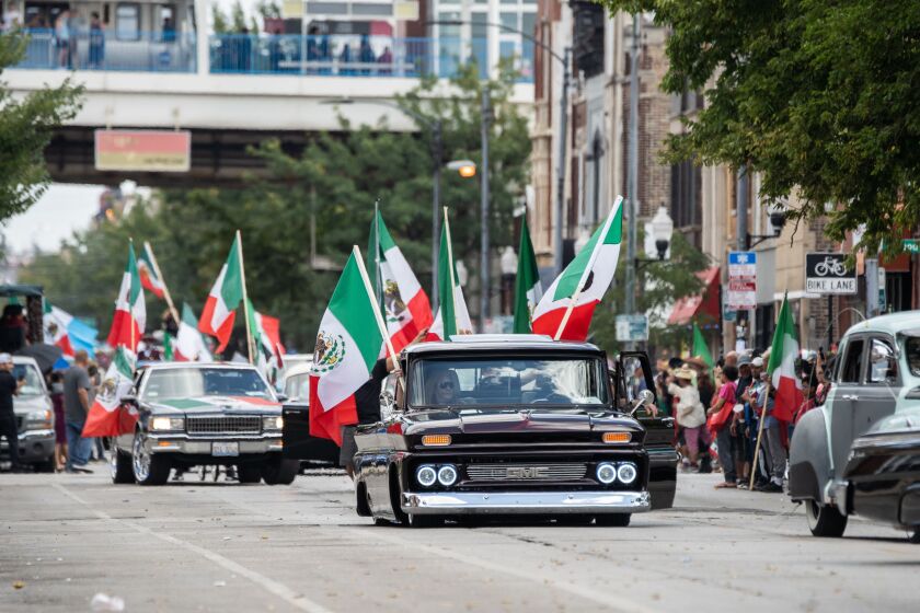 Paradegoers ride lowrider cars during the 20th annual Mexican Independence Day Parade along West 18th Street in the Pilsen neighborhood, Saturday afternoon, Sept. 10, 2022.