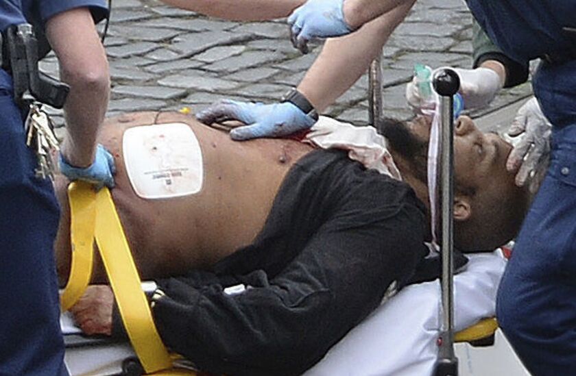 The attacker, Khalid Masood, is treated by emergency services outside the Houses of Parliament London on Wednesday after police shot him. | Stefan Rousseau/Press Association, distributed by the Associated Press