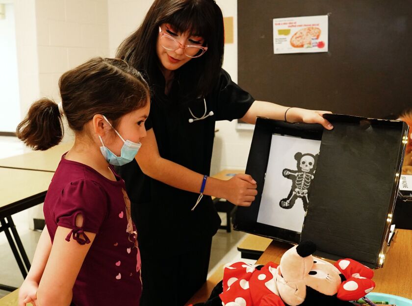 Angela Casas shows an x-ray from Victoria Mesta‘s Minnie Mouse doll during the teddy bear check-ups for students at Eli Whitney Elementary in Chicago Thursday, April 27, 2023.