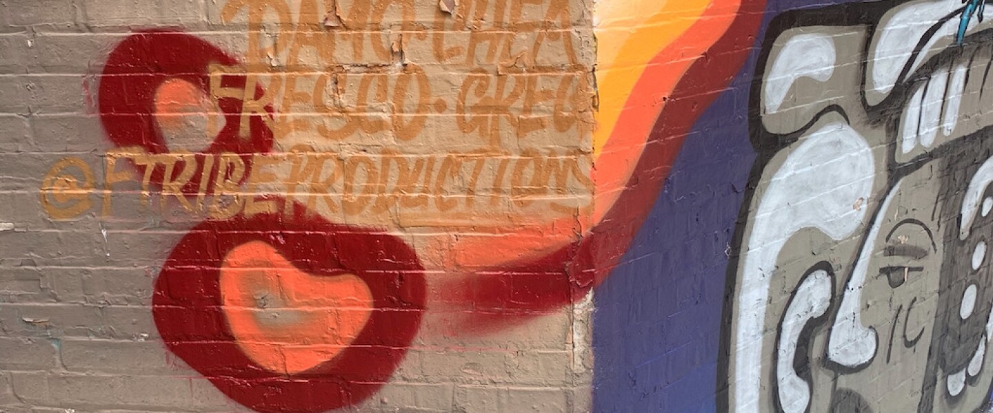 Around the corner to the left of the toucan and Maya statue is a list of artists who worked on the mural.