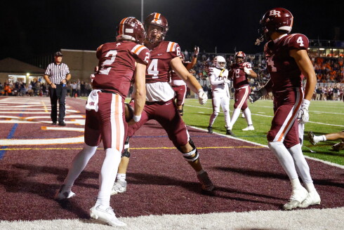 Brother Rice's Sam Holcomb (2) is celebrated by Tyler Houlf (64) after scoring a touchdown against Mount Carmel.