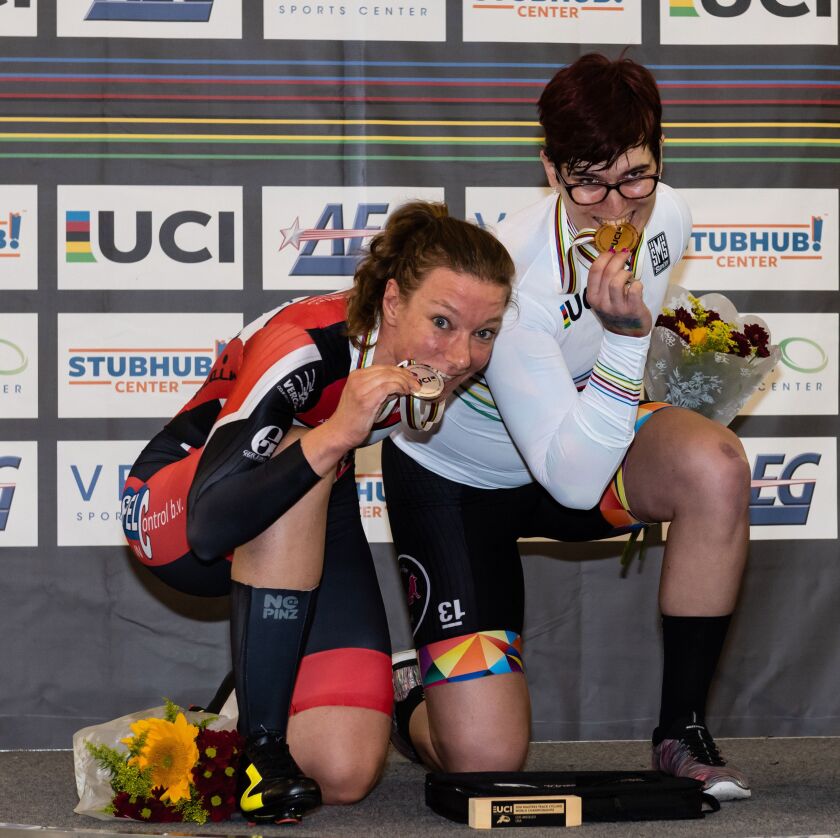 In this Oct. 13, 2018 photo provided by Craig Huffman, transgender cyclist Rachel McKinnon of Canada, right, bites her gold medal with silver medalist Carolien Van Herrikhuyzen of the Netherlands during the UCI Masters Track Cycling World Championships in