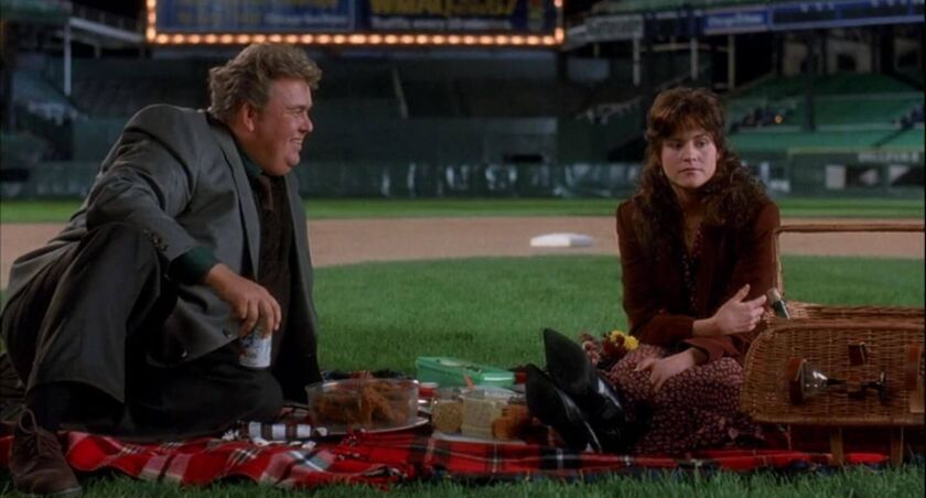 Danny (John Candy) treats Theresa (Ally Sheedy) to a picnic on the field at Comiskey Park in “Only the Lonely.” | TWENTIETH CENTURY FOX