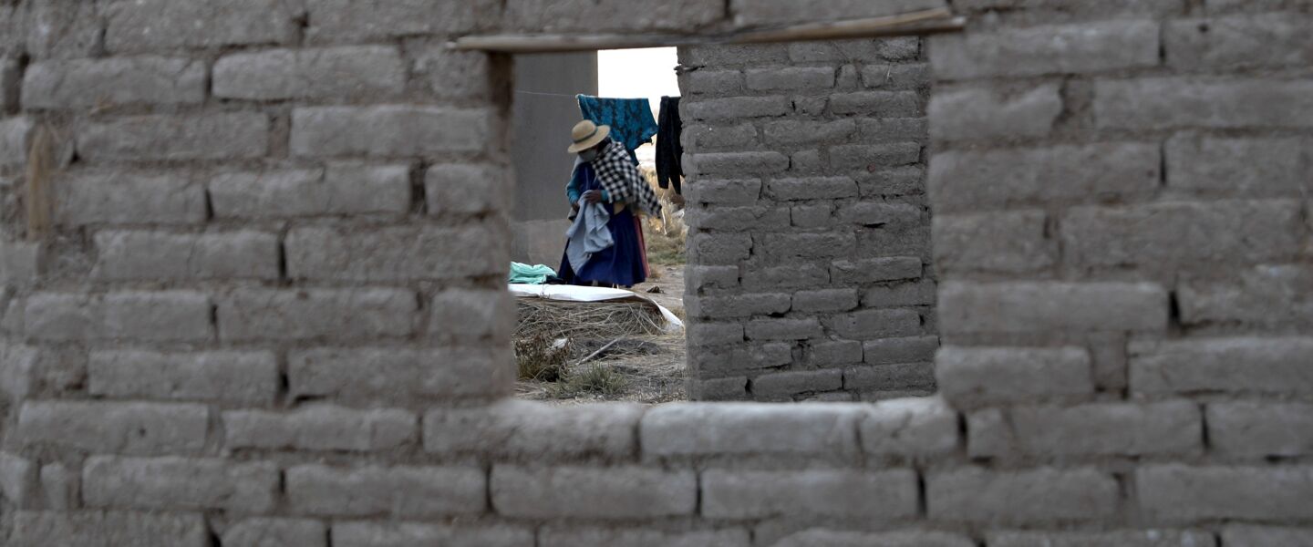 A woman removes her dried laundry from a clothesline in the Urus del Lago Poopo indigenous community in Punaca, Bolivia.