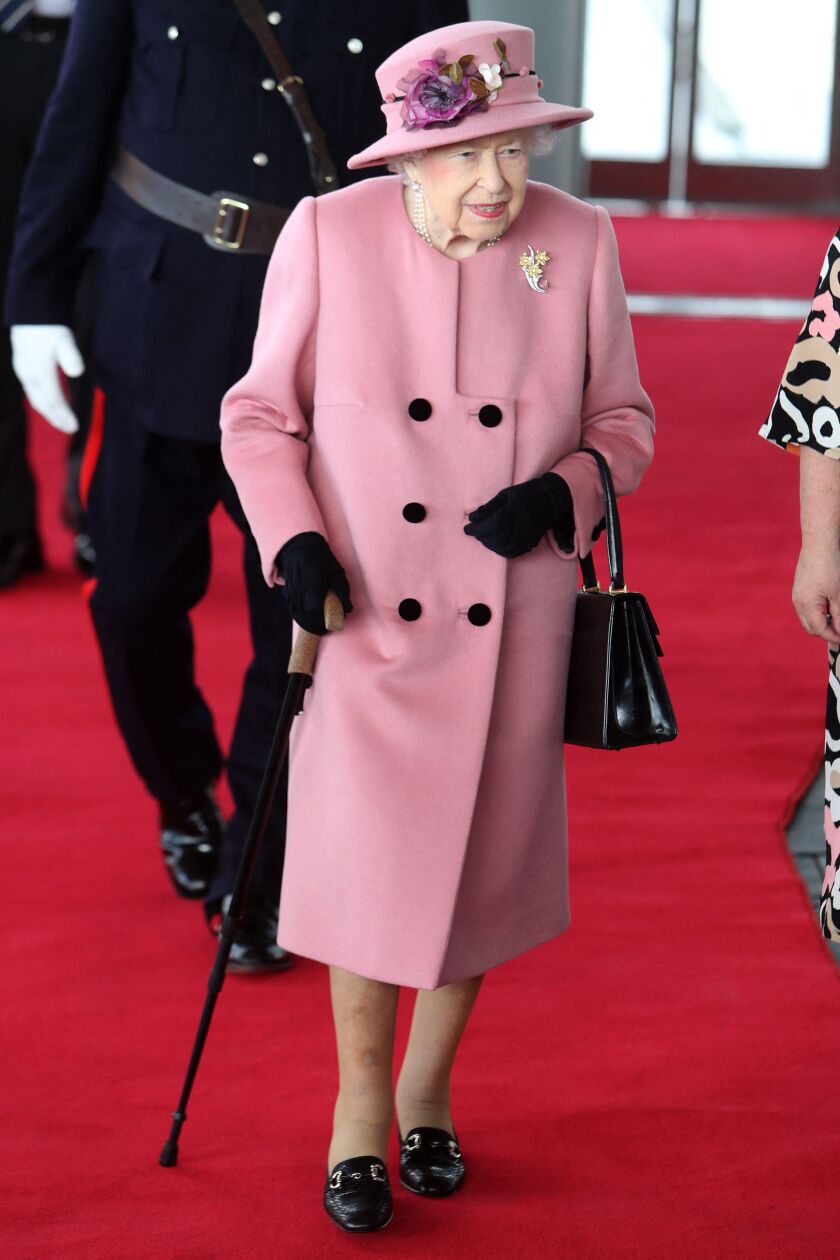 In this file photo taken on October 14, 2021 Britain’s Queen Elizabeth II is shown using a walking stick during her arrival to attend the ceremonial opening of the sixth Senedd, in Cardiff, Wales.