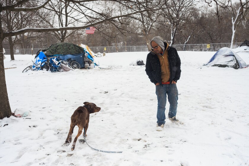 Leonilo Laude, 39, tries to calm a dog belonging to one of the neighboring tents at an encampment near West Admore Avenue at Legion Park in North Park, Monday, March 16, 2026. | Anthony Vazquez/Sun-Times
