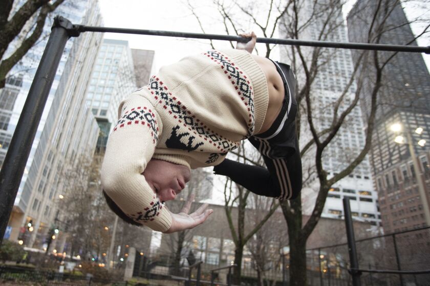 William Slotwinski, 25, performs a esquadra, which is a gimbarr element, on the calisthenic bars at Lake Shore Park in the Streeterville neighborhood on November 21, 2019 in Chicago, Ill. | Colin Boyle for the Sun-Times